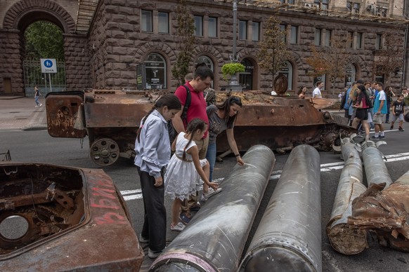 epa10130457 People look at Russian armoured military vehicles and items that were destroyed in fights with the Ukrainian army, displayed on Khreshchatyk street, in downtown Kyiv, ahead of the &#039;In ...