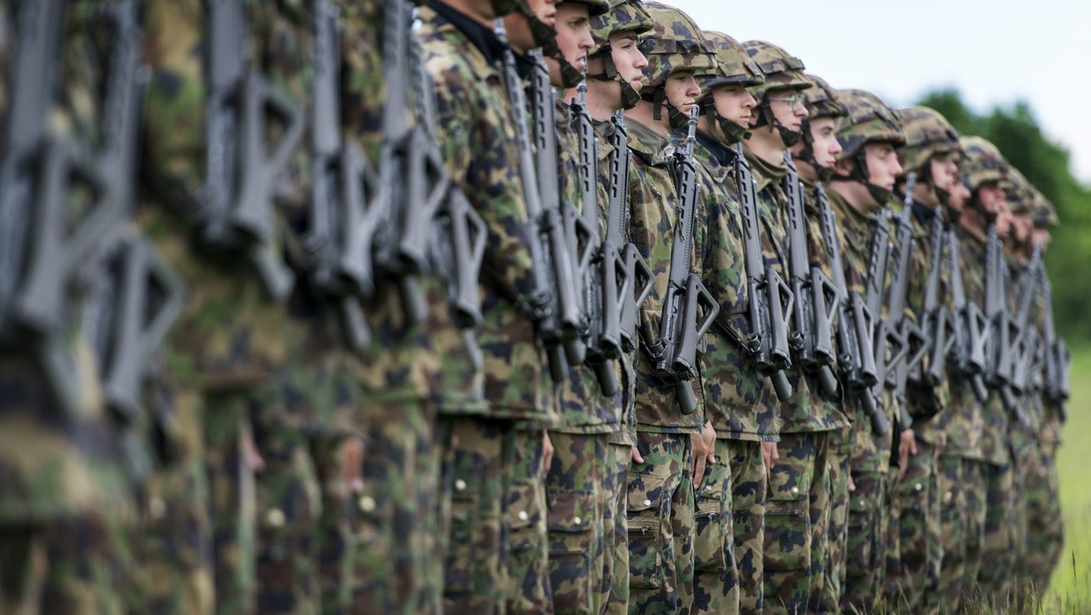 Infantry recruits stand in a row on a green field, pictured on May 17, 2013, in the infantry recruit school of the Swiss army in Colombier, canton of Neuchatel, Switzerland. (KEYSTONE/Christian Beutle ...