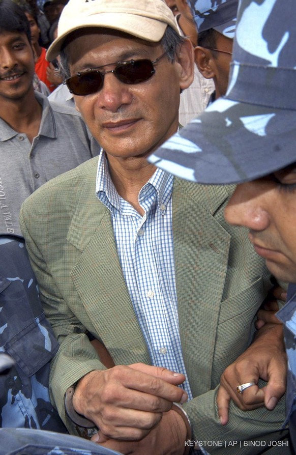 FILE - Police escort convicted French serial killer Charles Sobhraj from court in Katmandu, Nepal on Aug. 12, 2004. Confessed serial killer Sobhraj, who was convicted and sentenced to life in prison i ...