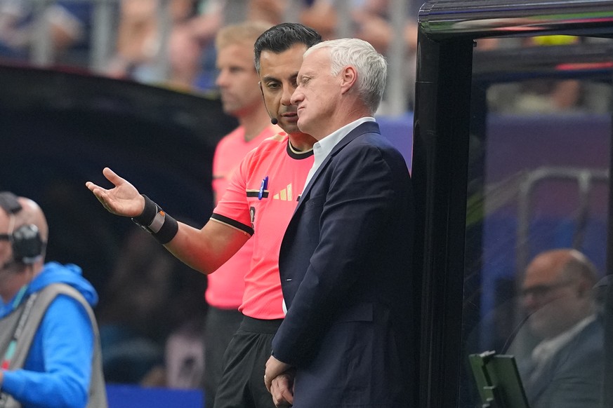 A referee assistant talks to France head coach Didier Deschamps during a World Cup semifinal soccer match against Spain in Arlington, Texas, near Dallas, Tuesday, July 14, 2026. (AP Photo/Julio Cortez ...