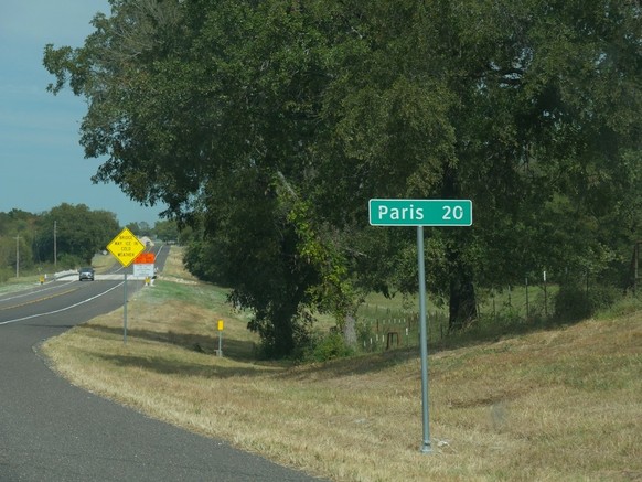 Ein Strassenschild/Wegweiser, welches den Weg nach Paris (Texas) anzeigt.
