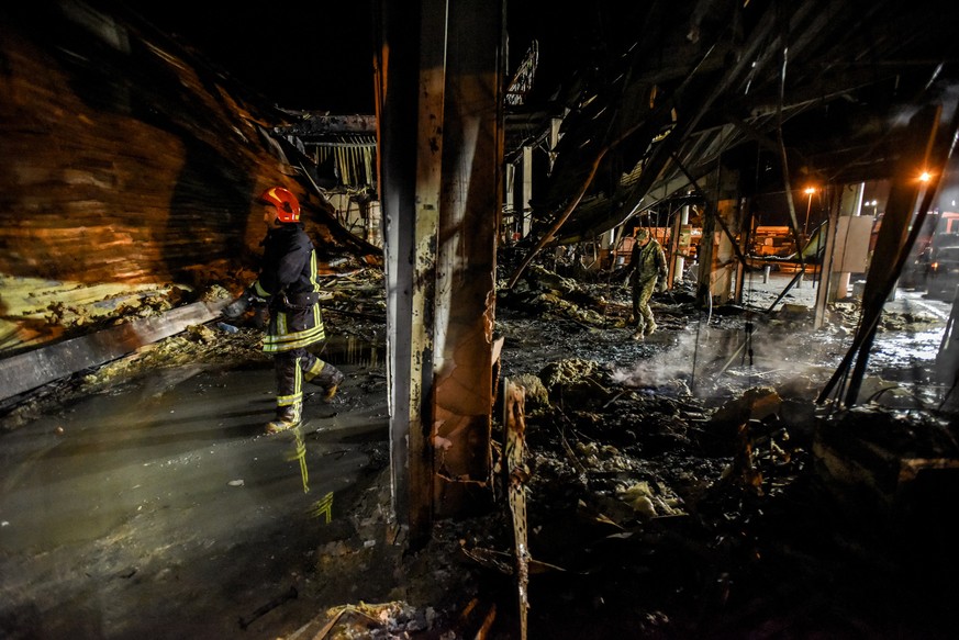 epa10037595 Firefighters clean the rubble of the destroyed Amstor shopping mall in Kremenchuk, Poltava Oblast, Ukraine, 27 June 2022. At least eleven bodies were found dead at the scene, the State Eme ...