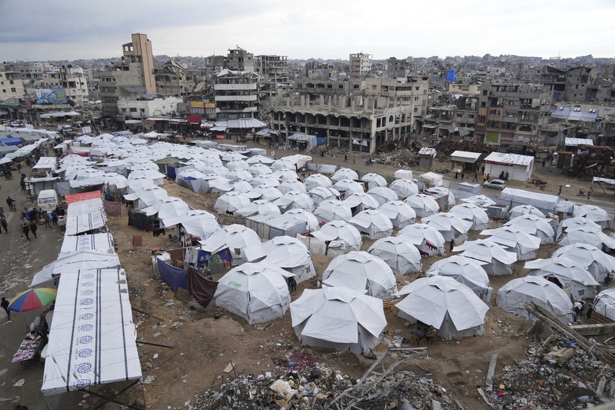 A sprawling tent camp for displaced Palestinians sits adjacent to destroyed homes and buildings in Gaza City, Gaza Strip, Saturday, March 1, 2025 during the Muslim holy month of Ramadan. (AP Photo/Abd ...