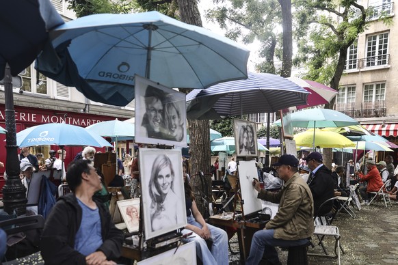 epa12277895 Artists work on drawings and sketches at Place du Tertre square, in Montmartre, Paris, France, 01 August 2025. The Montmartre district in northern Paris welcomes about 11 million visitors  ...