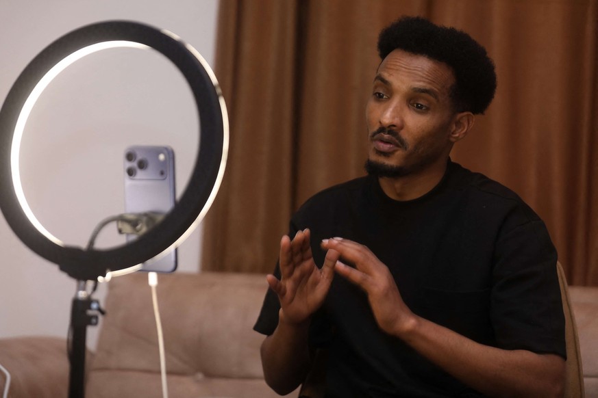 Mahad Maxamud interagit avec ses followers lors d&#039;un direct sur les réseaux sociaux à Mogadiscio, le 6 décembre 2025.