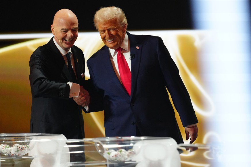 President Donald Trump is greeted by FIFA President Gianni Infantino during the draw for the 2026 soccer World Cup at the Kennedy Center in Washington, Friday, Dec. 5, 2025. (Jia Haocheng/Pool Photo v ...