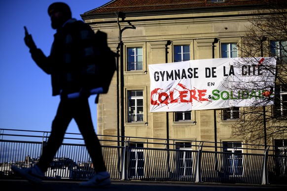 Une personne passe devant une banderole &quot;Gymnase de la Cite en colere et solidaire&quot; placee sur la facade du Gymnase de la Cite lors d&#039;une journee d&#039;action et de greve du secteur de ...