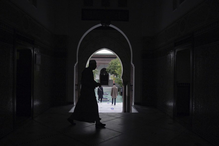 A man walks inside the Paris mosque, Thursday, Oct. 29, 2020. The beheading of a teacher outside his school just as President Emmanuel Macron goes on a war footing to rout out extremists has forced Fr ...