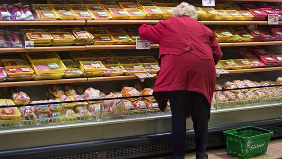 Eine Frau kauft bei einem Regal mit Fleisch am 20. Januar 2005 am 20. Januar 2005 im Migros Limmatplatz in Zuerich ein. Neben ihr steht ein Warenkorb mit der Aufschrift &amp;quot;Frischland&amp;quot;. ...