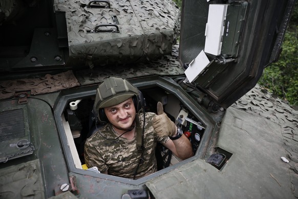 A Ukrainian soldier gives the thumb-up sign on a Swedish CV90 infantry fighting vehicle at his positions near Bakhmut, Donetsk region, Ukraine, Sunday, June 25, 2023. (Roman Chop via AP)