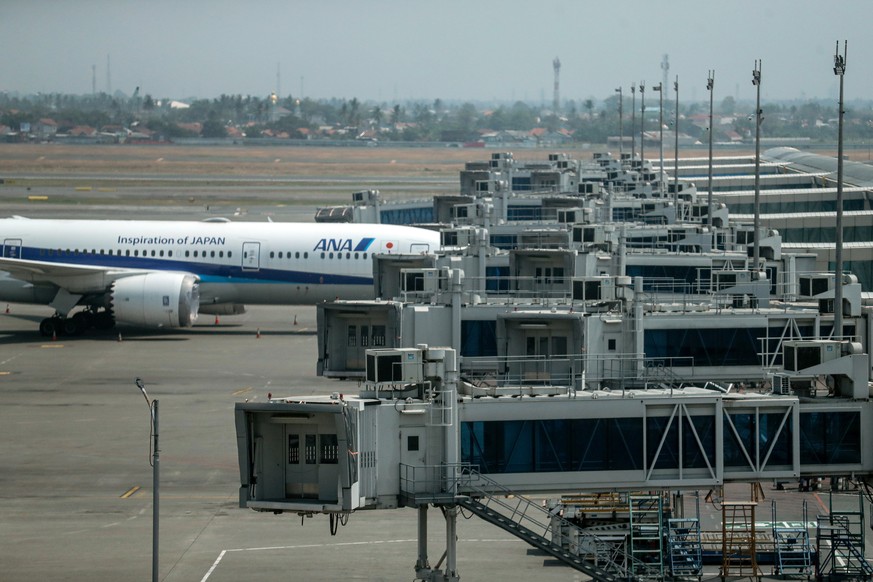 epa13216460 An airplane of the Japanese airline All Nippon Airways (ANA) is parked on the tarmac as flights are cancelled at the Soekarno-Hatta International Airport, in Tangerang, on the outskirts of ...