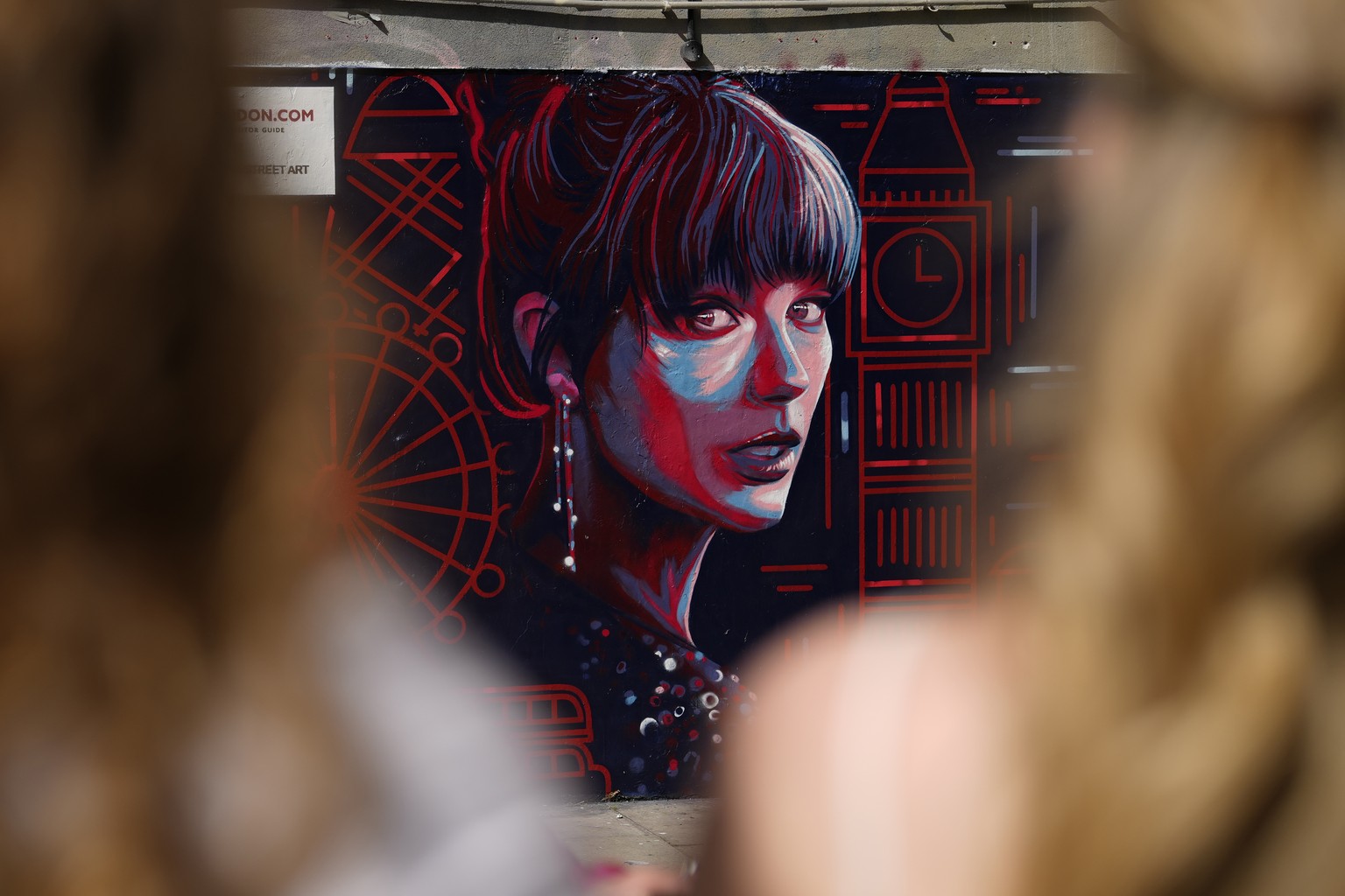 People look at a new mural portrait of Taylor Swift designed by Kate Clayton which was unveiled in Shoreditch in east London, Tuesday, Aug. 13, 2024. (AP Photo/Alastair Grant)
