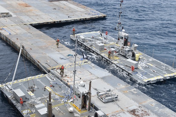In this image provided by the U.S. Army, soldiers assigned to the 7th Transportation Brigade (Expeditionary) and sailors attached to the MV Roy P. Benavidez assemble the Roll-On, Roll-Off Distribution ...
