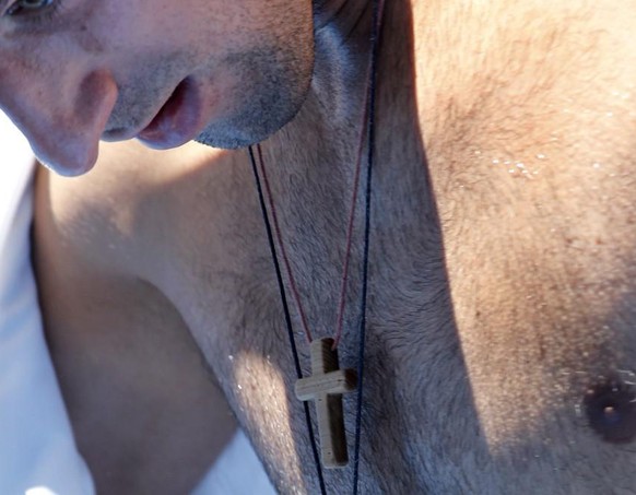 epa03063018 Novak Djokovic of Serbia dries off as he changes his shirt as his cross and star-shaped pendant swing around his neck, after winning his men&#039;s first round singles match against Paolo  ...