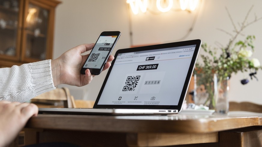 [Staged Picture] A person does online shopping on a laptop by using the Twint payment app on a smartphone, photographed in Bern, Switzerland, on May 2, 2018. (KEYSTONE/Christian Beutler)