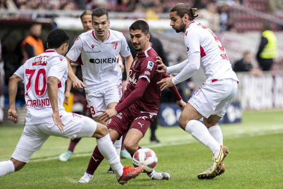 Le milieu genevois Alexis Antunes, lutte pour le ballon avec le defenseur valaisan Marquinhos Cipriano, gauche, le milieu valaisan Kevin Bua, centre, et le defenseur valaisan Jan Bamert, droite, lors  ...