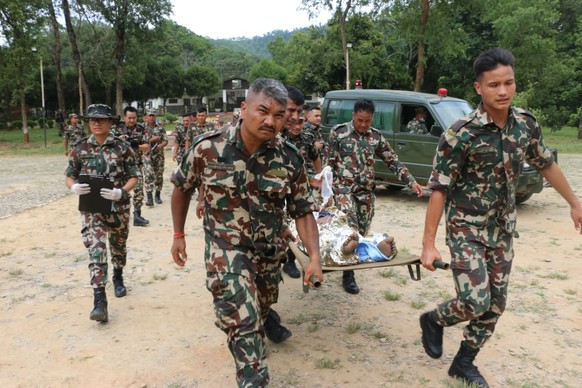 epa13193700 A handout photo made available by the Nepal Army shows army officers conducting a helicopter rescue of survivors following a flash flood in Trishuli Bazar, Nuwakot district, Nepal, 26 Augu ...