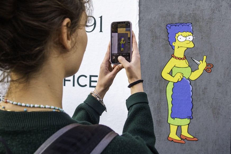 epa10235595 The Cut 2, the sequel, a mural created by the street artist AleXsandro Palombo shows Marge Simpson, a character in the animated sitcom 'The Simpsons,' shows her 'middle fing ...