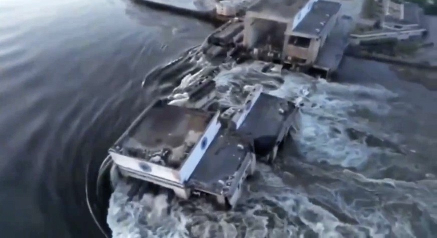 In this image taken from video released by the Ukrainian Presidential Office, water runs through a breakthrough in the Kakhovka dam in Kakhovka, Ukraine, Tuesday, June 6, 2023. Ukraine on Tuesday accu ...