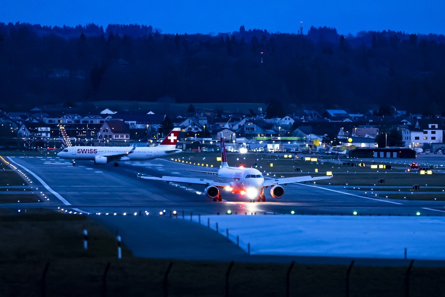 Flugzeuge der Fluggesellschaft Swiss rollen am Abend in der Dunkelheit auf der Piste 28 am Flughafen Zuerich Kloten, am Donnerstag 9. Januar 2025 in Zuerich Kloten. (KEYSTONE/Michael Buholzer)
