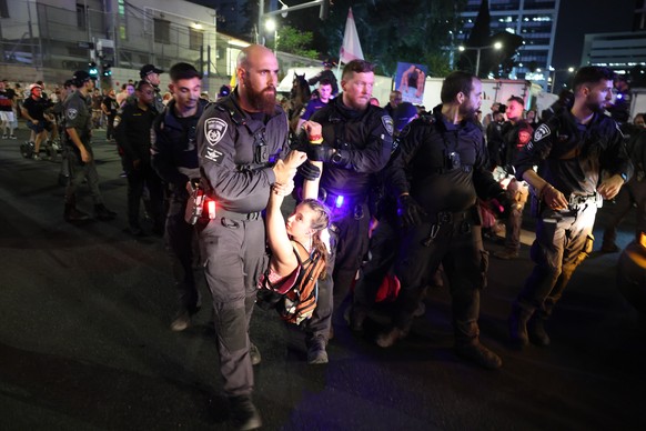 epa12291692 Police detain a protester participating with families of Israeli hostages held by Hamas in Gaza calling on the government to sign a hostages release and ceasefire deal, outside the Kirya m ...