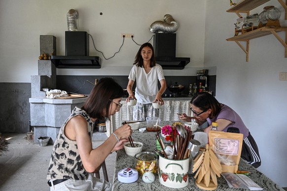 The photo taken on July 15, 2025 shows Chen Yani (C), also known as &quot;Keke&quot; preparing breakfast for the guests in a female co-living space called &quot;Kekeís Imaginative Space&quot; in Hangz ...