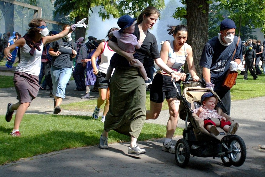 Anti-globalisation protestors, with maks, send away bystanders with young children as riot police officers spray tear gas during a anti G8 demonstration in Lausanne, Switzerland, Sunday, June 1st, 200 ...