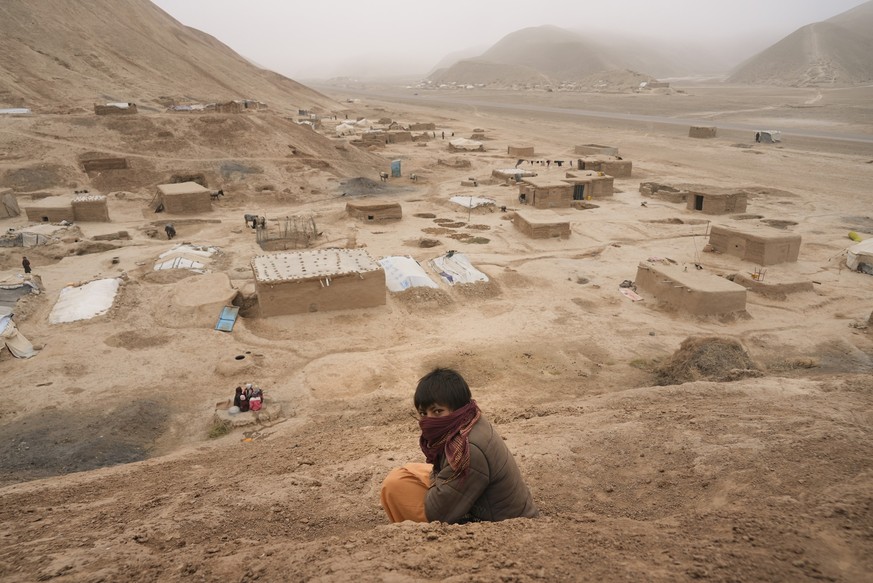 An Afghan boy sits on the hill overlooking the IDP camp near Qala-e-Naw, Afghanistan, Tuesday, Dec. 14, 2021. Severe drought has dramatically worsened the already desperate situation in Afghanistan fo ...