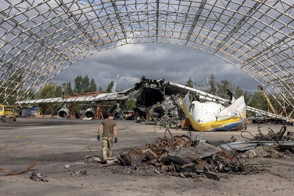 epa10149712 A man works at the site next to the cargo aircraft Antonov An-225 Mriya &#039;Dream&#039; that was destroyed during the Russian attacks, at the Hostomel Airfield, northwest of the capital  ...