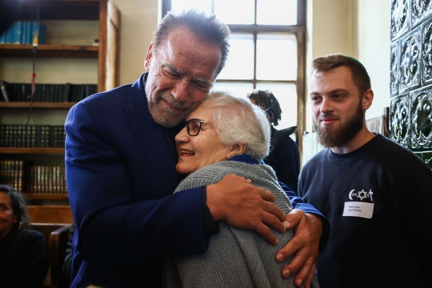 Arnold Schwarzenegger hugs Lidia Maksymowicz, holocaust survivor, during a visit inside a former synagogue that now is home to the Auschwitz Jewish Center Foundation, after visiting former Nazi German ...