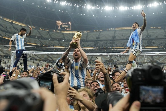 Argentina&#039;s Lionel Messi celebrates with the trophy in front of the fans after winning the World Cup final soccer match between Argentina and France at the Lusail Stadium in Lusail, Qatar, Sunday ...