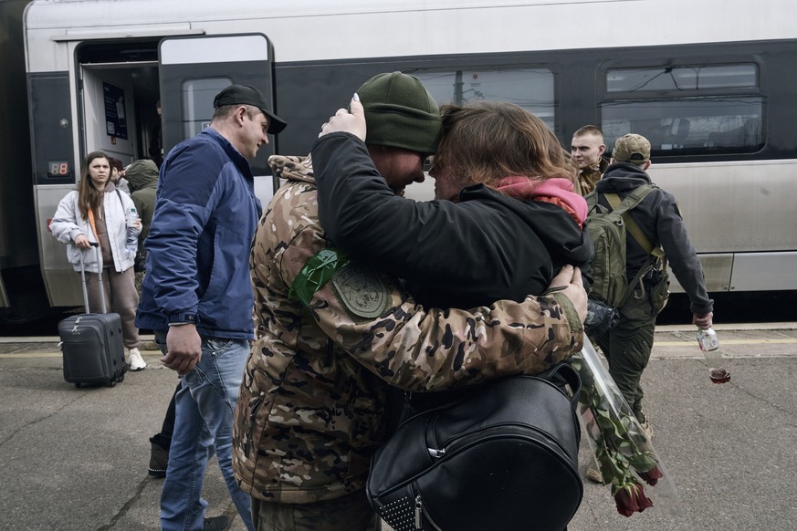 A Ukrainian soldier meets his wife at a railway station in Kramatorsk, Donetsk region, Ukraine, Tuesday, March 21, 2023. (AP Photo/Libkos)