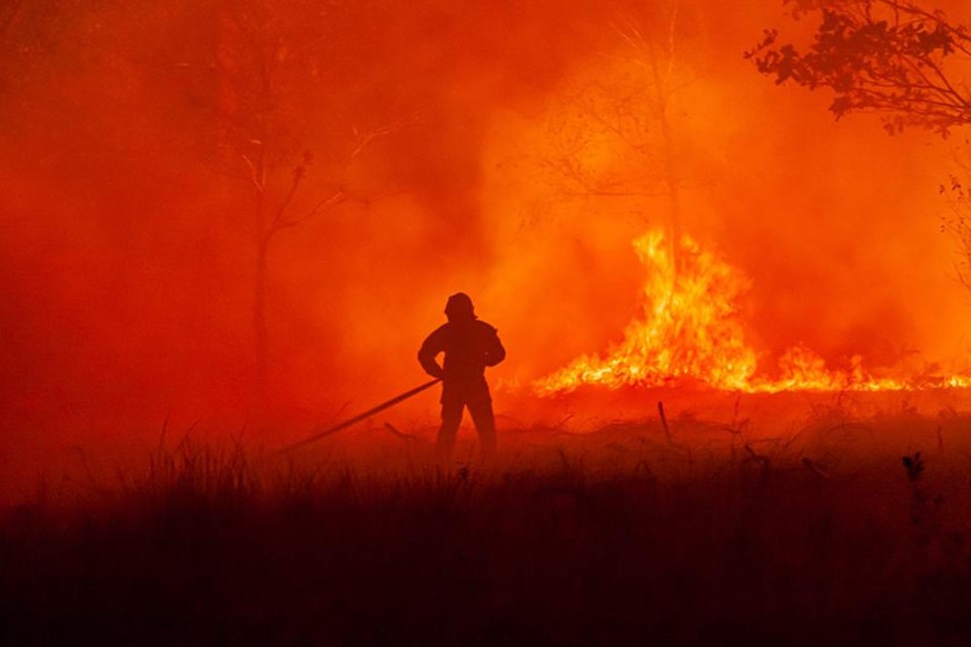 This photo provided by the SDIS33 fire brigade shows a fireman battling in a wildfire on a fire near the village of Saumos, southwestern France, Tuesday Sept.13, 2022. New wildfires raging in southwes ...