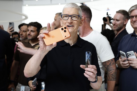 epa12365646 Apple CEO Tim Cook holds the new Apple iPhone 17 Pro and iPhone 17 Air at an Apple product launch event on the campus of Apple Park in Cupertino, California, USA, 09 September 2025. EPA/JO ...