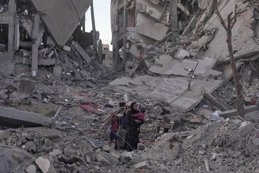 Une femme palestinienne avec ses enfants dans les ruines de la ville de Gaza.