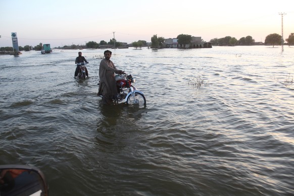 epa10241291 People affected by floods move to higher grounds in KPN Shah, Sindh province , Pakistan, 13 October 2022. According to disaste?r management authorities, around 160 bridges and 5,000 km of  ...