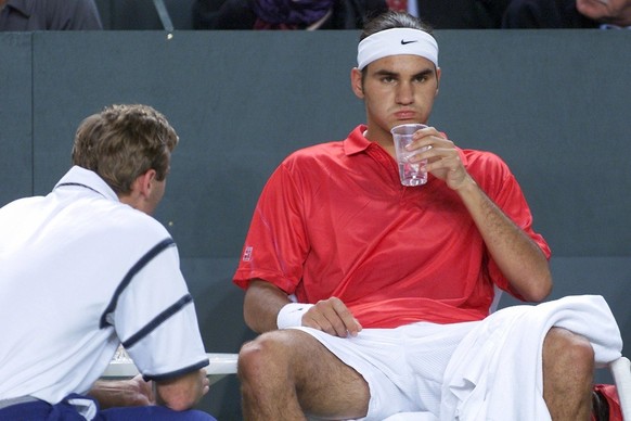 Swiss Roger Federer grimaces in front of his captain Jakob Hlasek having a rest in the play vs Arnaud Clement, during the 4th quarter-final Davis Cup tennis game Switzerland vs France, in Neuchatel, S ...