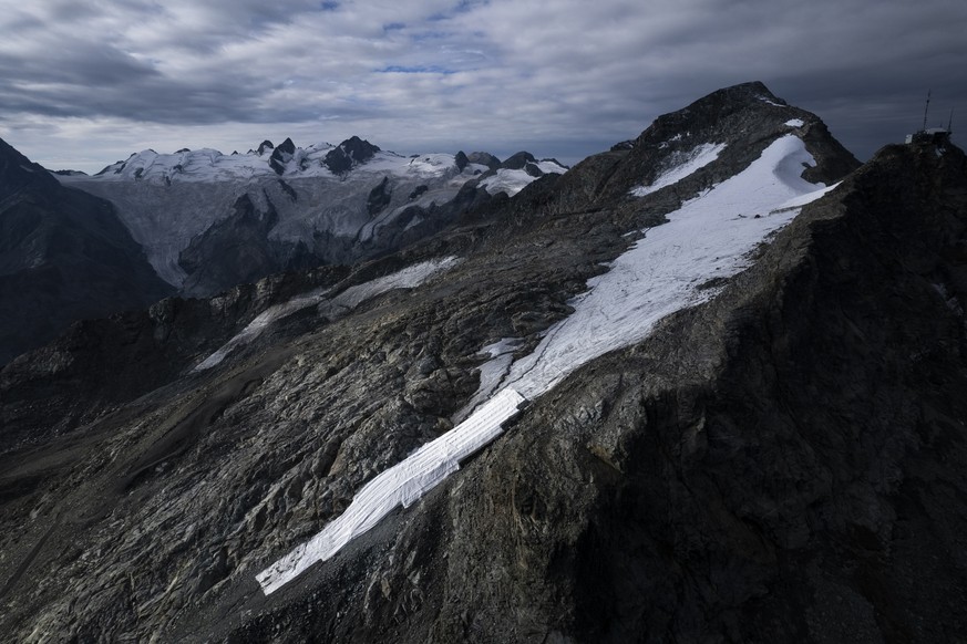 Blick auf den Corvatsch-Gletscher, waehrend Mitarbeiter der Bergbahnen Gletscher-Schutzvlies entfernen, aufgenommen am Montag, 5. September 2022, in Samedan. Das Schweizerische Gletschermessnetz