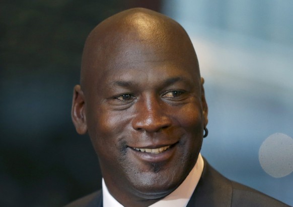 Michael Jordan smiles at reporters after a jury ordered a defunct grocery store chain to pay him $8.9 million for using his name without permission. Friday, Aug. 21, 2015, in Chicago. Jurors had to ca ...