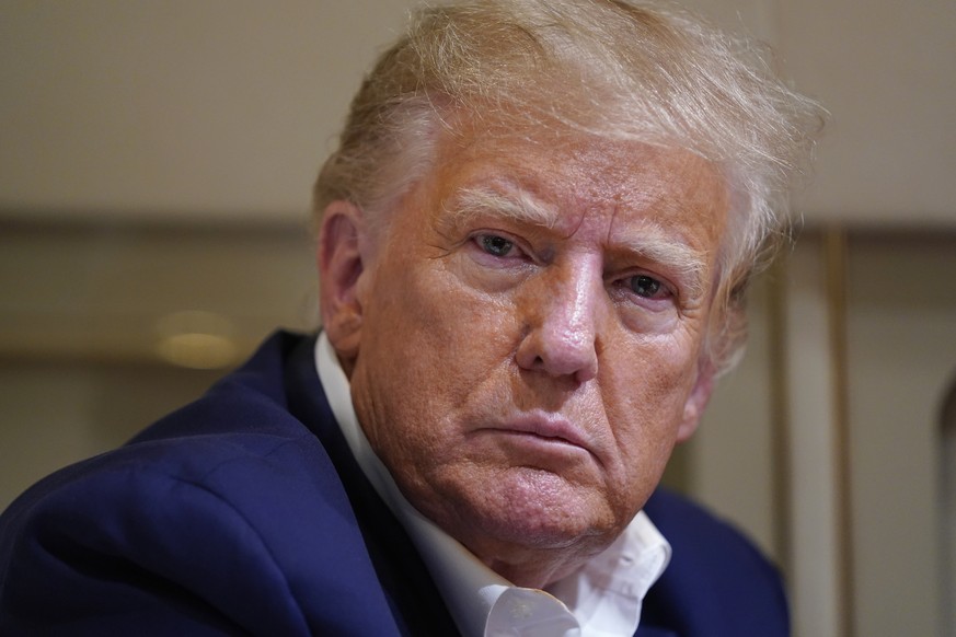 Former President Donald Trump listens as he speaks with reporters while in flight on his plane after a campaign rally at Waco Regional Airport, in Waco, Texas, Saturday, March 25, 2023, while en route ...