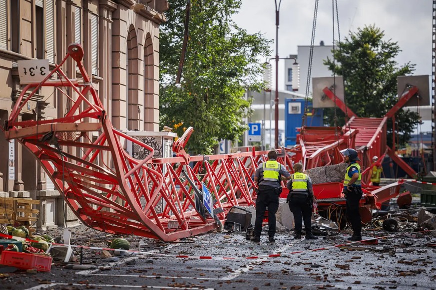 La police et les pompiers déblayent la grue renversée qui se trouvait sur la place de la gare de La Chaux-de-Fonds.