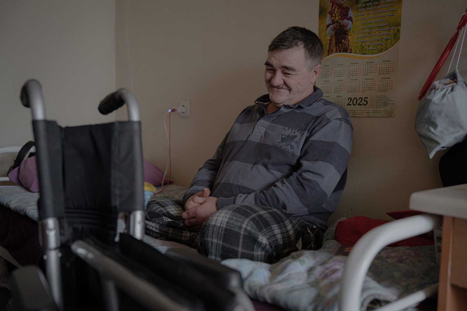 Resident Sergiy Yukovsky sits on a bed in his room at a shelter for senior citizens in Kharkiv on March 26, 2025, amid the Russian invasion of Ukraine. The war has disproportionately affected Ukraine& ...