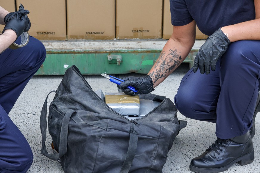 epa10741991 Customs officials illustrate the finding of cocaine in a shipping container as part of a presentation of seizures of cocaine for the first semester in the Port of Antwerp, in Antwerp, Belg ...