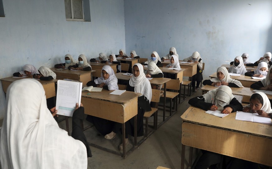 FILE - Afghan girls students attend school classes in a primary school in Kabul, Afghanistan, Saturday, March 27, 2021. Schools for all students will open this week, Afghanistan's Taliban-run Edu ...