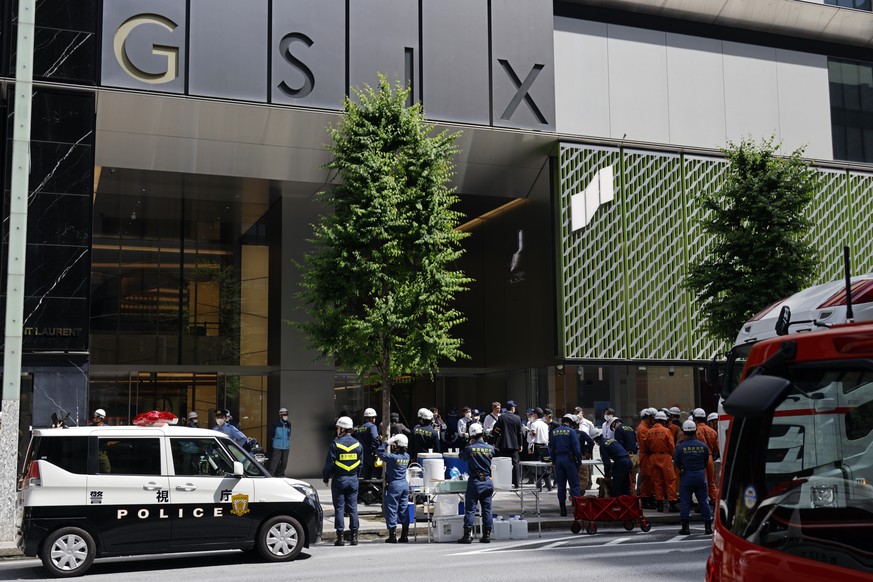 epa12992293 Firefighters and police officers stand in front of the Ginza Six luxury shopping complex in Tokyos Ginza district, Japan, 25 May 2026. Authorities said there is information that a man all ...
