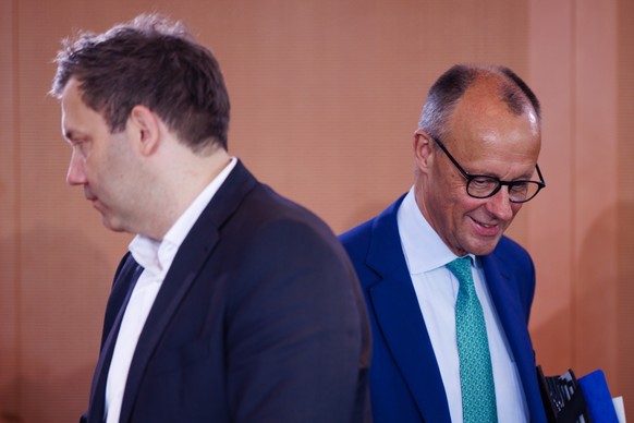 epa12240399 German Chancellor Friedrich Merz (R) arrives next to German Finance Minister Lars Klingbeil at the start of a meeting of the German government at the Chancellery in Berlin, Germany, 16 Jul ...