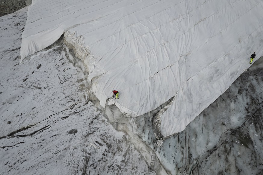 Blick auf den Corvatsch-Gletscher, waehrend Mitarbeiter der Bergbahnen Gletscher-Schutzvlies entfernen, aufgenommen am Montag, 5. September 2022, in Samedan. Das Schweizerische Gletschermessnetz �Glac ...