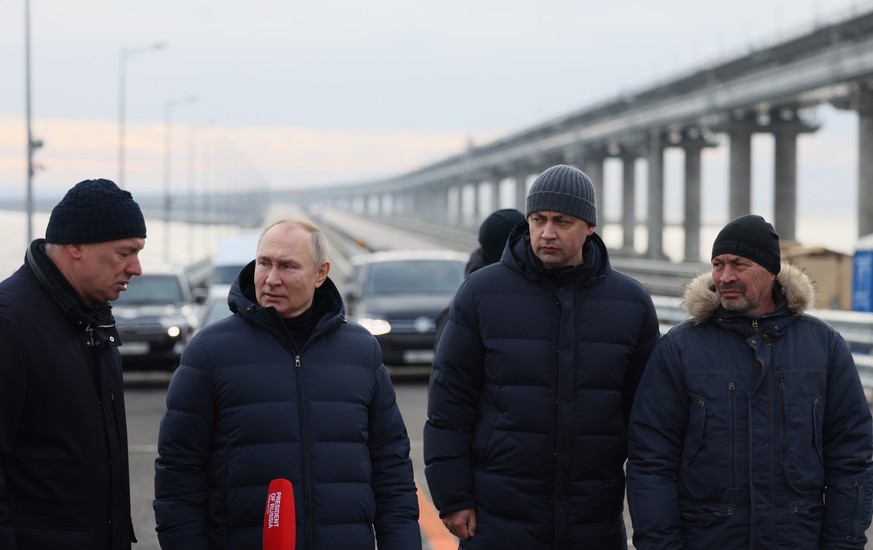 Vladimir Poutine écoute le rapport du vice-premier ministre russe Marat Khousnoulline (gauche) sur la restauration du pont du détroit de Kertch, en Crimée, le 5 décembre 2022. Le pont - qui est une au ...