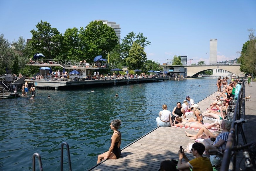 ZURICH, SWITZERLAND - JUNE 10: People enjoy the warm weather along the river Limmat on June 10, 2023 in Zurich, Switzerland. Temperatures are reaching 25 degrees celsius around large parts of Zurich o ...