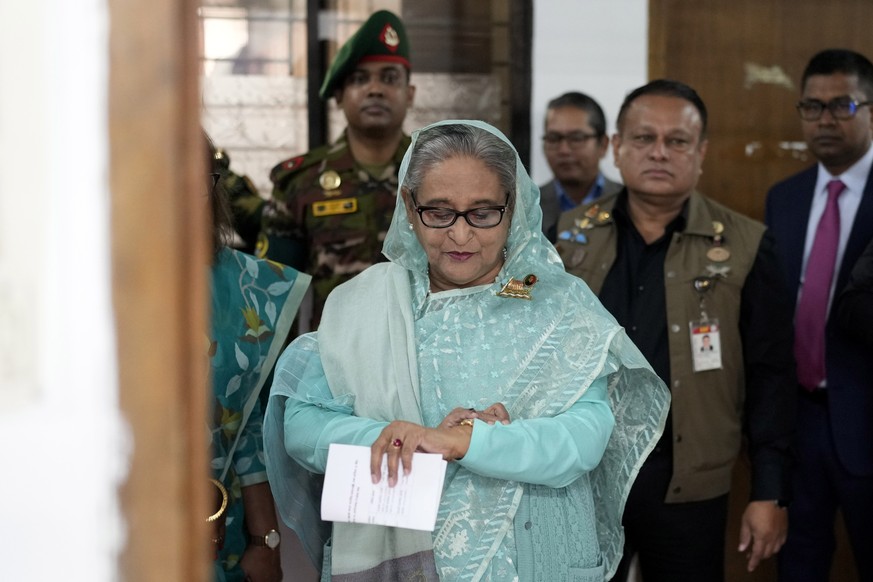 FILE- Bangladesh Prime Minister Sheikh Hasina checks her watch as she waits for the official opening time to cast her vote in Dhaka, Bangladesh, Sunday, Jan. 7, 2024. (AP Photo/Altaf Qadri, File)